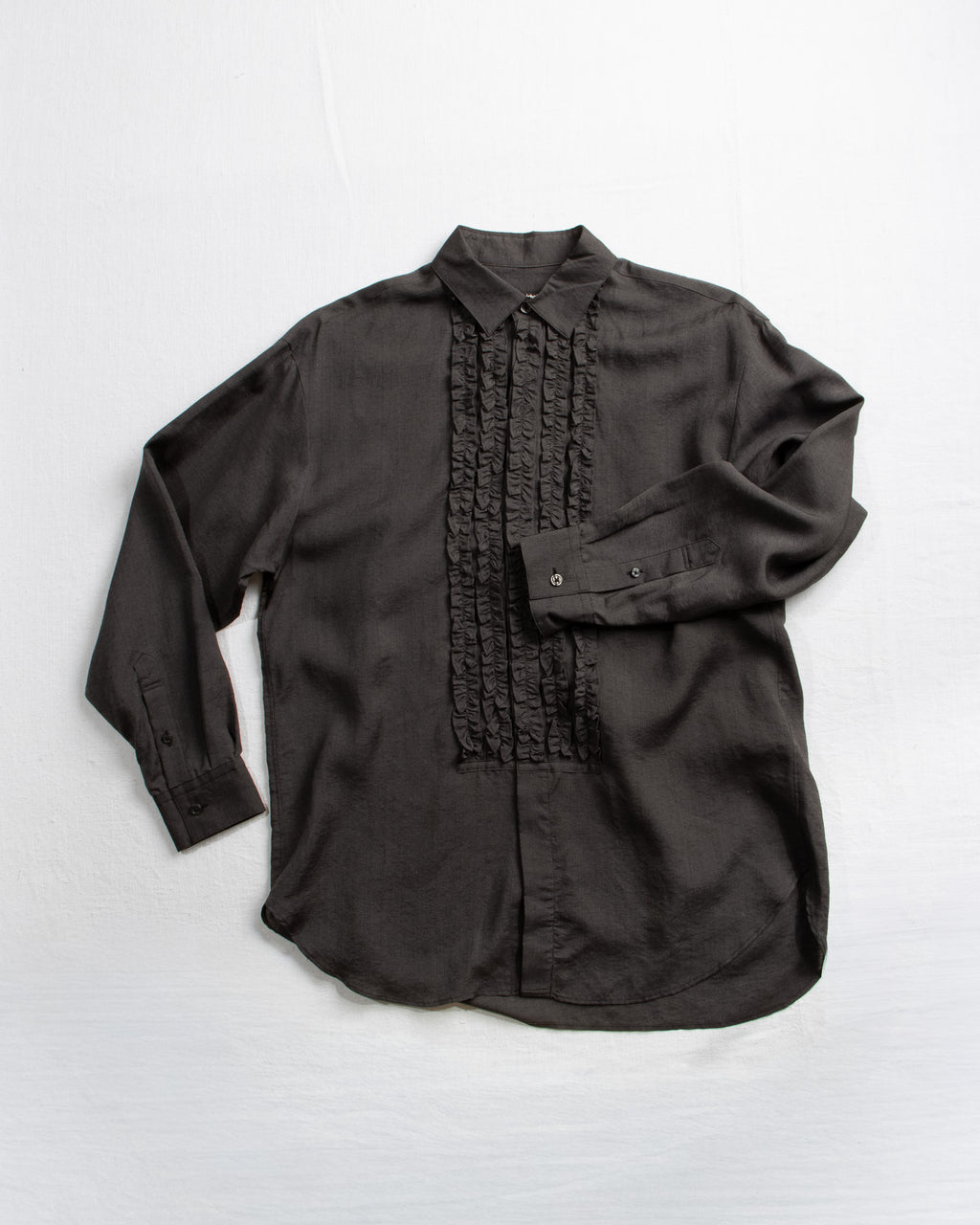 Black shirt with ruffled front panel on a white background